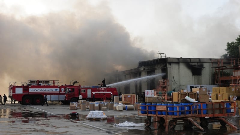 Pakistani firefighters extinguish fires at the airport