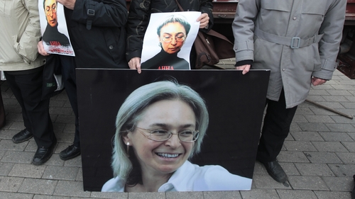 People hold photos as they attend a commemoration rally in honour Anna Politkovskaya in 2012