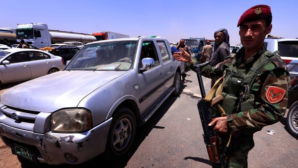 Iraqi families fleeing violence in the northern Nineveh province gather at a Kurdish checkpoint