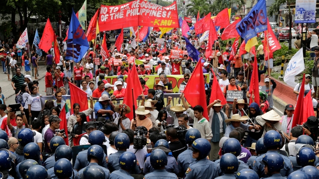 Filipino protesters are blocked by ant-riot police during a protest rally to mark the 116th year of Philippine Independence