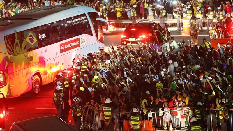 Fans cheer and take photos as the Brazilian team bus departs outside Itaquerao stadium