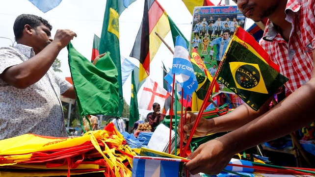 A street vendor displays small flags of Brazil and Argentina and other World Cup related products at a street market in Dhaka, Bangladesh