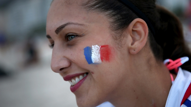 A French football fans sports her country's colours as she enjoys Copacabana beach before the start of the World Cup