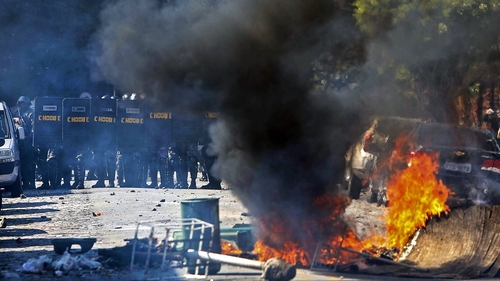 Riot policemen stand in position during an anti-World Cup protest on the morning the Brazilian mega-city Sao Paulo hosts the tournament's opening match