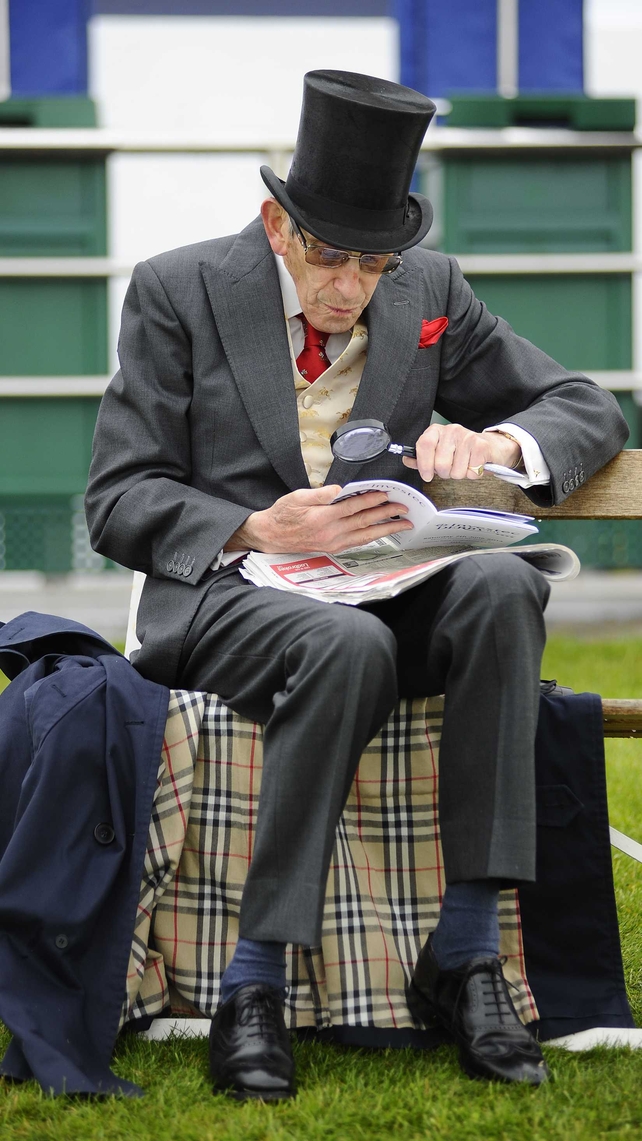 A racegoer checks the form with his magnifying glass at Epsom racecourse on Saturday