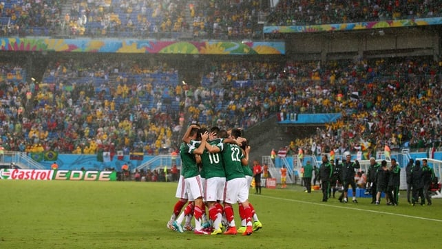 As time expires, the Mexican team celebrates their country's first World Cup win over an African side, with the final score standing at 1-0