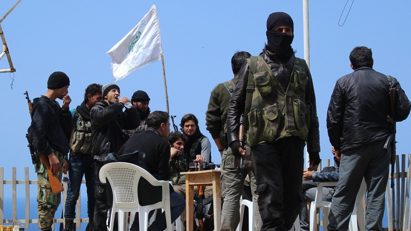 Rebel fighters from the Ansar al-Sham brigade hold a position on a ridge overlooking the Mediterranean sea reportedly in the village of Kasab