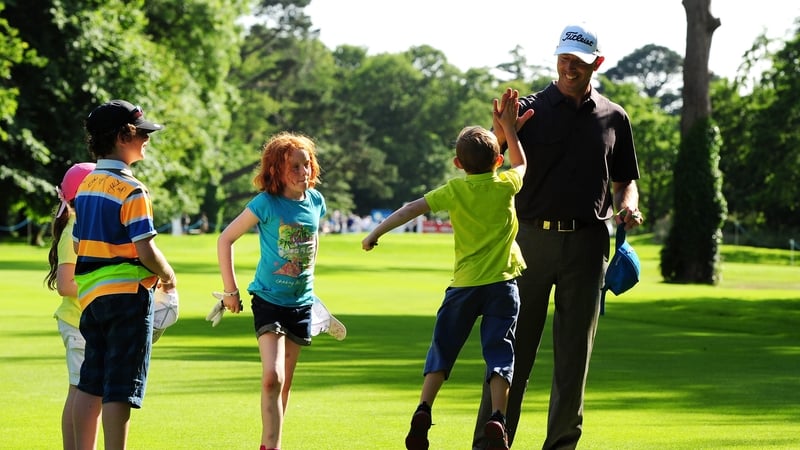 Soren Hansen of Denmark gets a high five from a young autograph hunter on 18th fairway during the Pro-Am day