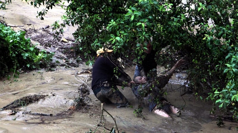 People try to help a man during a flood that hit Varna