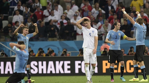 Gary Cahill reacts as Uruguay's players celebrate at the end of the game