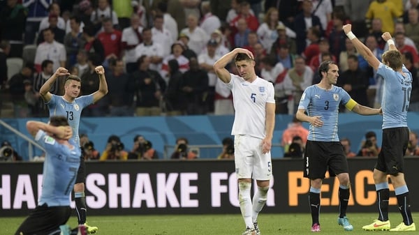 Gary Cahill reacts as Uruguay's players celebrate at the end of the game