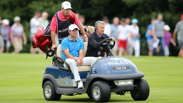 Rory McIlroy and caddie JP Fitzgerald are driven back to the fourth tee box to retake his drive on day two