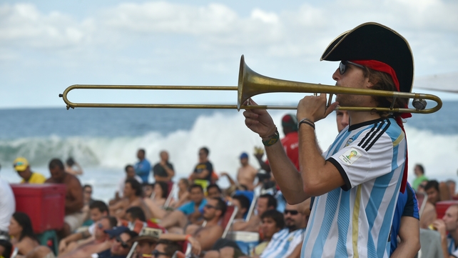An Argentinian fan plays a trombone on Copacabana beach in Rio de Janeiro