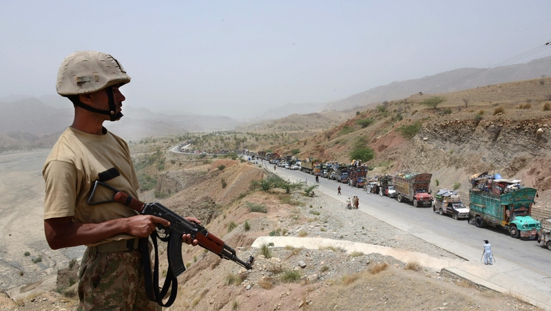 Pakistani civilians wait to cross a checkpoint at the Bannu Frontier Region registration centre for internally displaced people in Saidgai