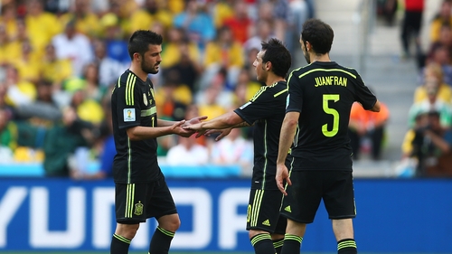 David Villa reacts with team-mates Juanfran and Santi Cazorla as he exits the game