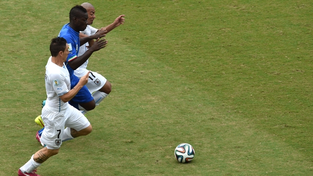 Uruguay's Cristian Rodriguez and Egidio Arevalo Rios vie with Italy forward Mario Balotelli during their game