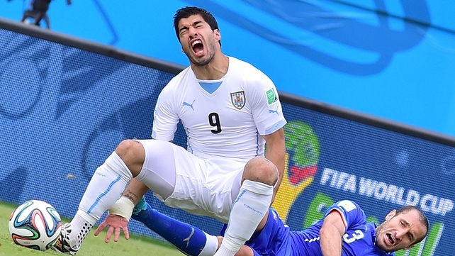 Uruguay forward Luis Suarez feels the full force of a Giorgio Chiellini challenge