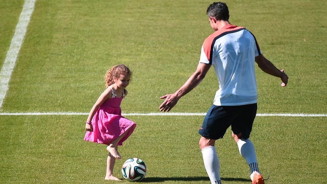 Elsewhere, Netherlands forward Robin van Persie plays with his daughter after a training session at the Flamengo Stadium