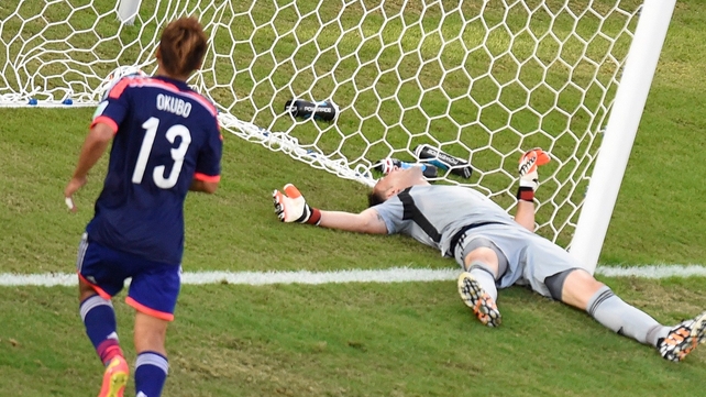 Yoshito Okubo looks on as Colombia's goalkeeper David Ospina lies on the ground following Shinji Okazaki's goal