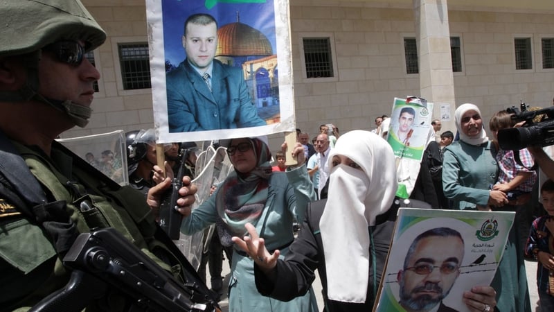 A Palestinian woman gestures to a member of Palestinian security forces after protesters were asked to stop a demonstration to express solidarity with prisoners on hunger strike