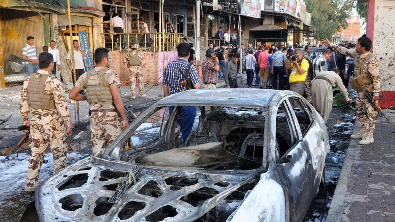 Iraqis gather at the site of a car bomb explosion in a Kurdish-majority neighbourhood of Kirkuk