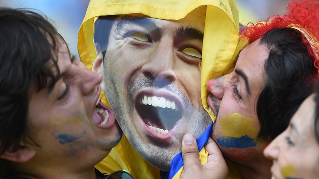 Colombia fans bite an image of Luis Suarez