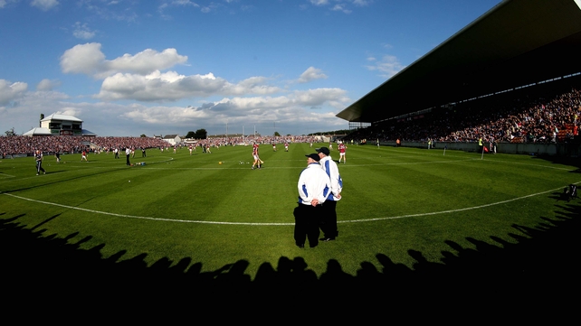 Two umpires watch the Galway team warm up ahead of their Leinster SHC semi-final against Kilkenny