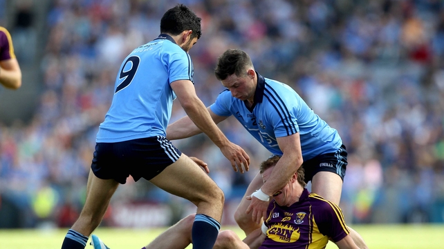 Tiarnan Rossitor feels the effect of tackling from Cian O'Sullivan and Philly McMahon