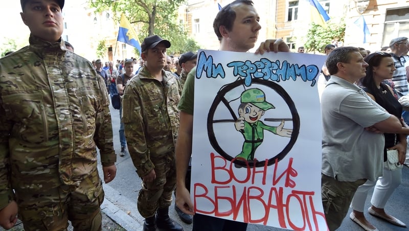 A man holds a sign reading 'We chat - they kill!' at a rally by Maidan activists at Independence Square in Kiev