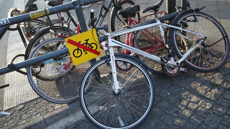 Bicycles lie chained to a barrier next to a sign explicity forbidding their presence at Alexanderplatz