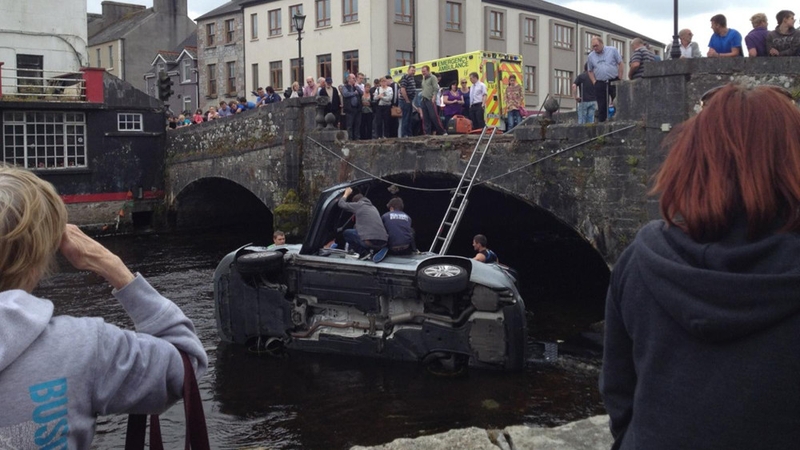 The car smashed through a concrete wall and ended on its side in shallow water