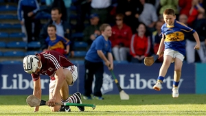 Galway’s Daithi Burke slumps to the ground dejected while a young Tipperary fan is elated after the match