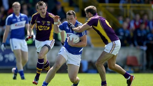 Laois' John O'Loughlin tries to avoid the presence of Brian Malone