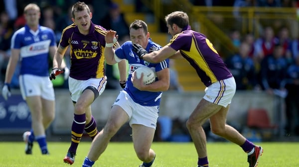 Laois' John O'Loughlin tries to avoid the presence of Brian Malone