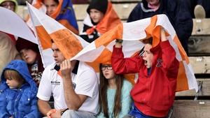 Armagh fans cover themselves from the rain in Clones
