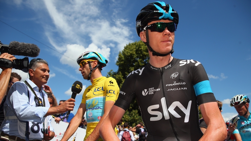 Chris Froome looks on while race leader Vincenzo Nibali talks to the press