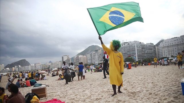 A Brazil fan held his country's flag at the Copacabana in Rio ahead of the match