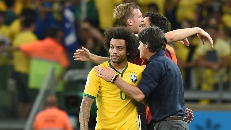 Joachim Loew comforts Brazil's defender Marcelo after the match between Brazil and Germany