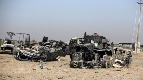 Burned and destroyed Iraq military vehicles are seen on a road in the town of Samarra