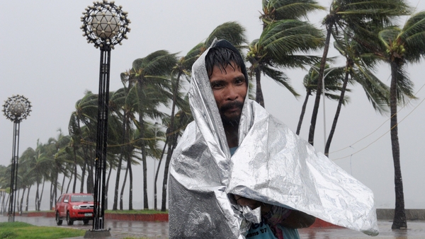 A man walks through heavy wind and rain as Typhoon Rammasun barrels across Manila