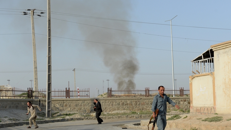 Afghans run for cover at the site of the attack in Kabul