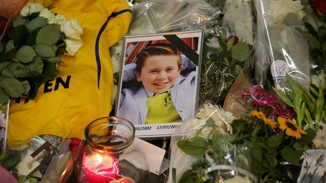 A photograph of a young boy lies amongst tributes at the entrance to Schiphol Airport