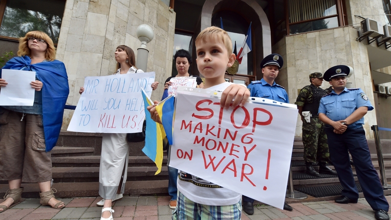 A young boy holds a sign during a demonstration in front of the French Embassy in Kiev