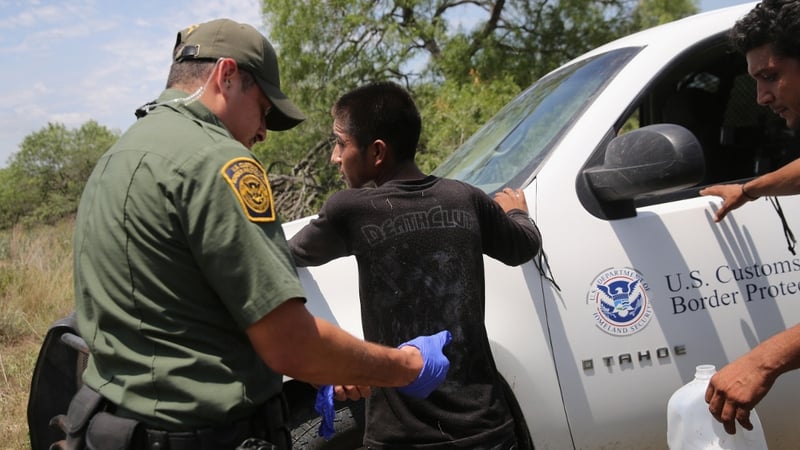 Border Patrol agents search an undocumented immigrant after taking him into custody