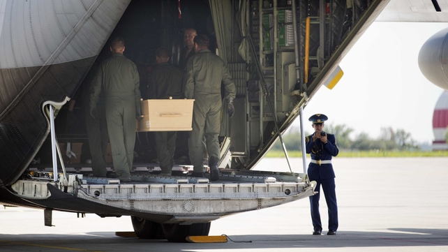 Soldiers carry a coffin on board a plane ahead of the journey to the Netherlands