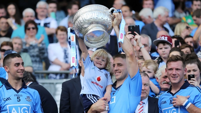 Eoghan O’Gara and his daughter Ella lift the Delaney Cup after the Leinster SFC final on Sunday