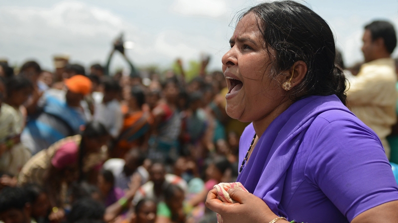 A mother mourns the loss of her son at the site of the collision