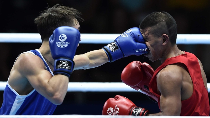 Michael Conlan (L) lands a punch to the face of Nauru's Mathew Martin during their men's bantamweight bout at the SECC