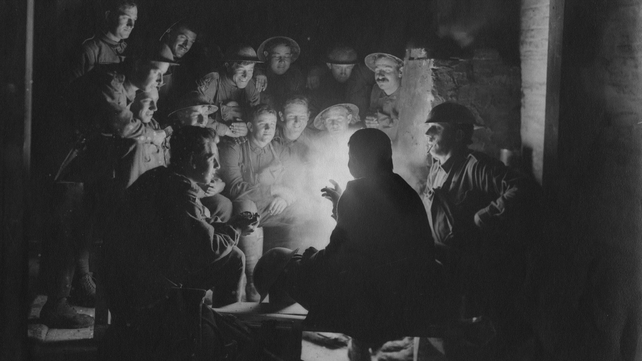 British soldiers sitting around a lamp in their trench