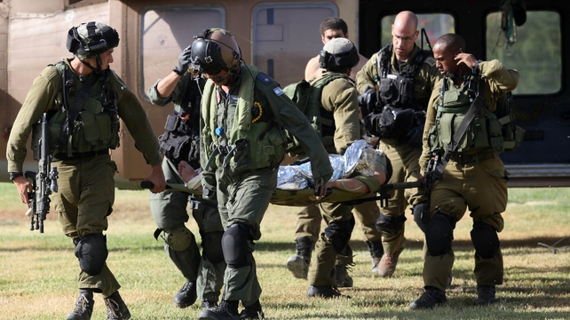 Israeli soldiers transport a wounded soldier from a helicopter at the Soroka Hospital